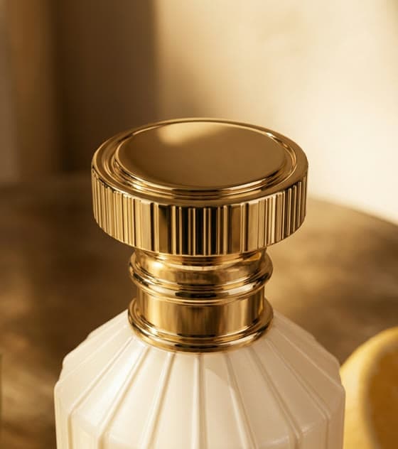 Il tappo dorato del flacone in luce radente